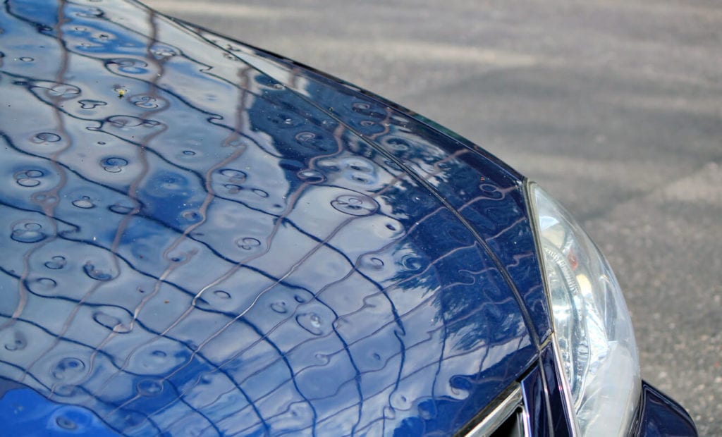 Car with dents from hail. 