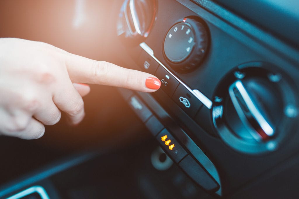 pushing the button to tunr on the A/C in a car