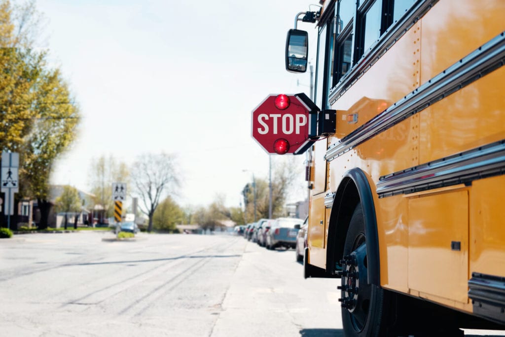 School bus stopped with stop sign present