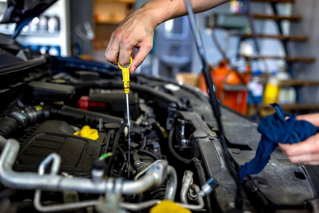 hand checking car oil level