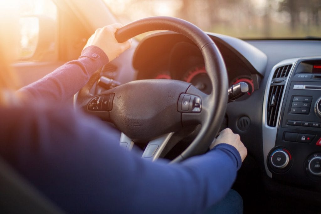 hand on a steering wheel of a car